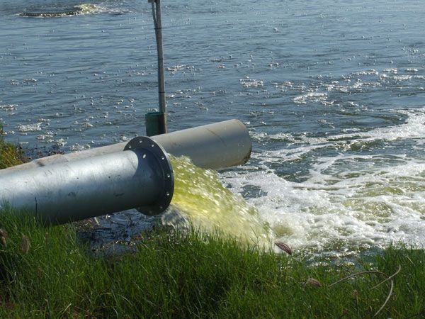A pipe is draining water into a body of water.