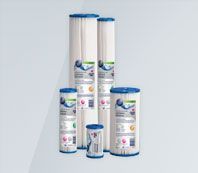 A group of water filter cartridges of different sizes are stacked on top of each other.