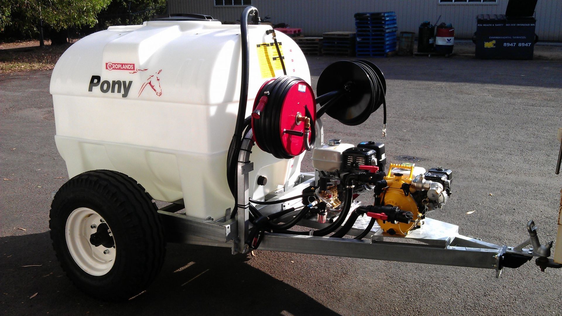 A white pony trailer is parked in a parking lot