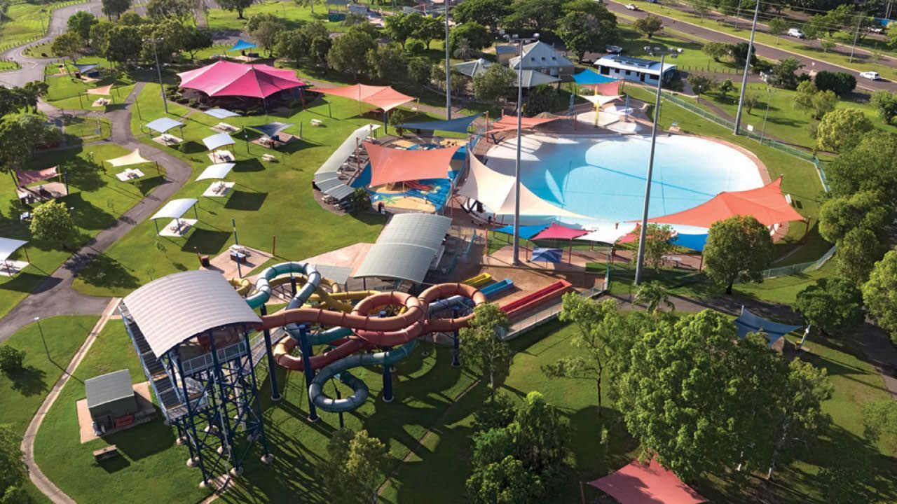 An aerial view of a water park with a large pool and a water slide.