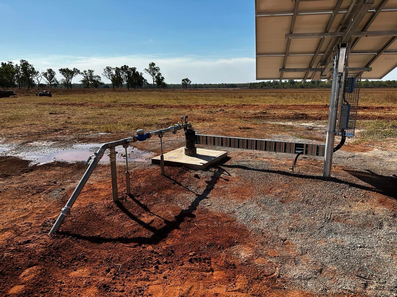 A solar panel is sitting in the middle of a field.