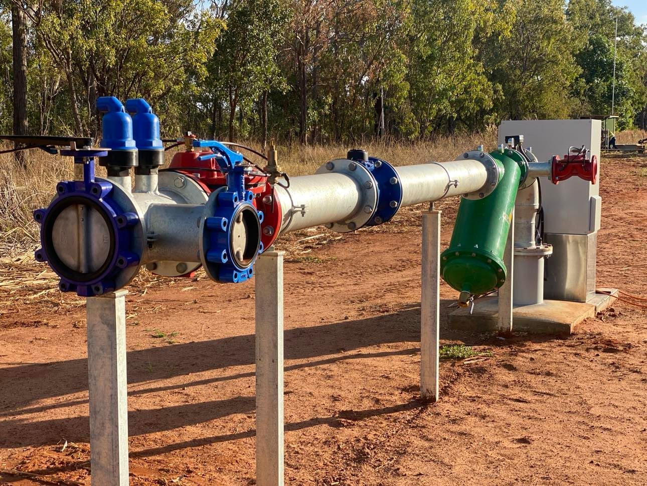 A row of pipes sitting on top of a dirt field.