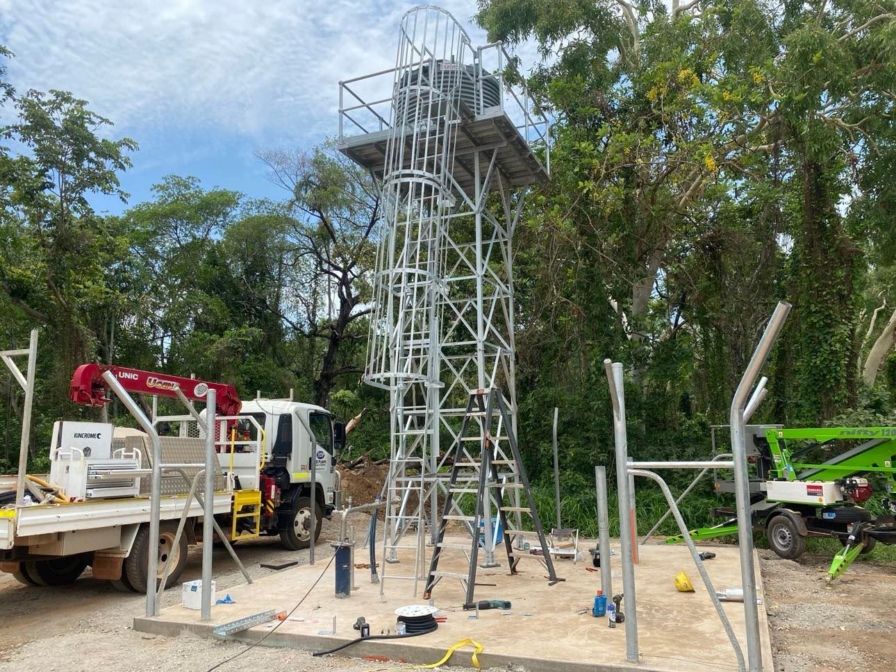 A construction site with a truck , crane , and ladder.
