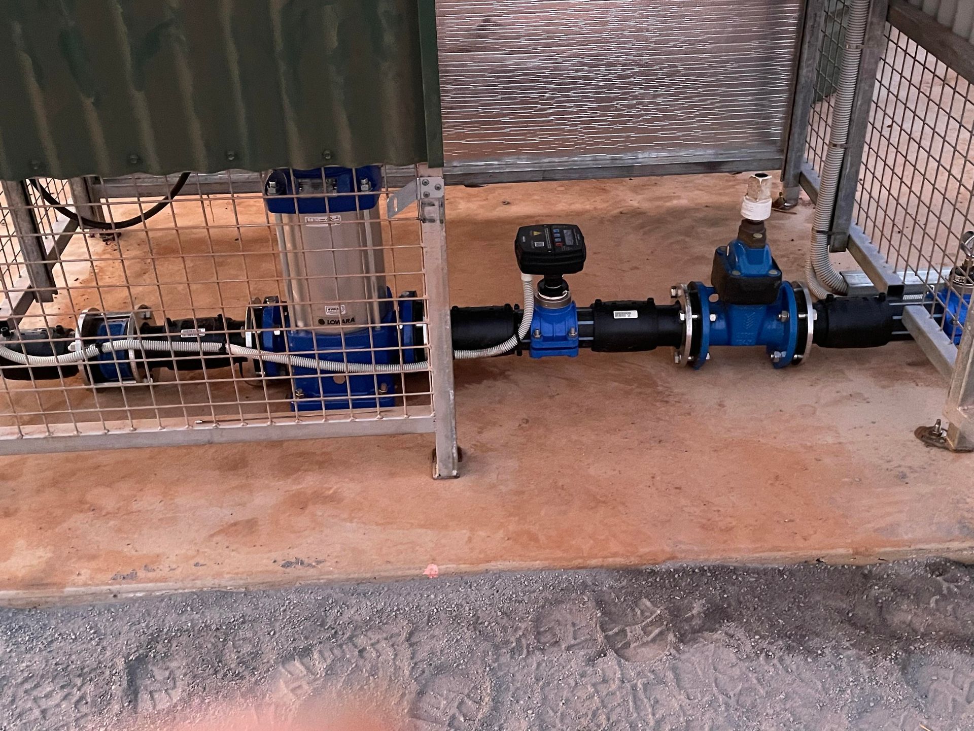 A bunch of blue pipes are connected to a fence