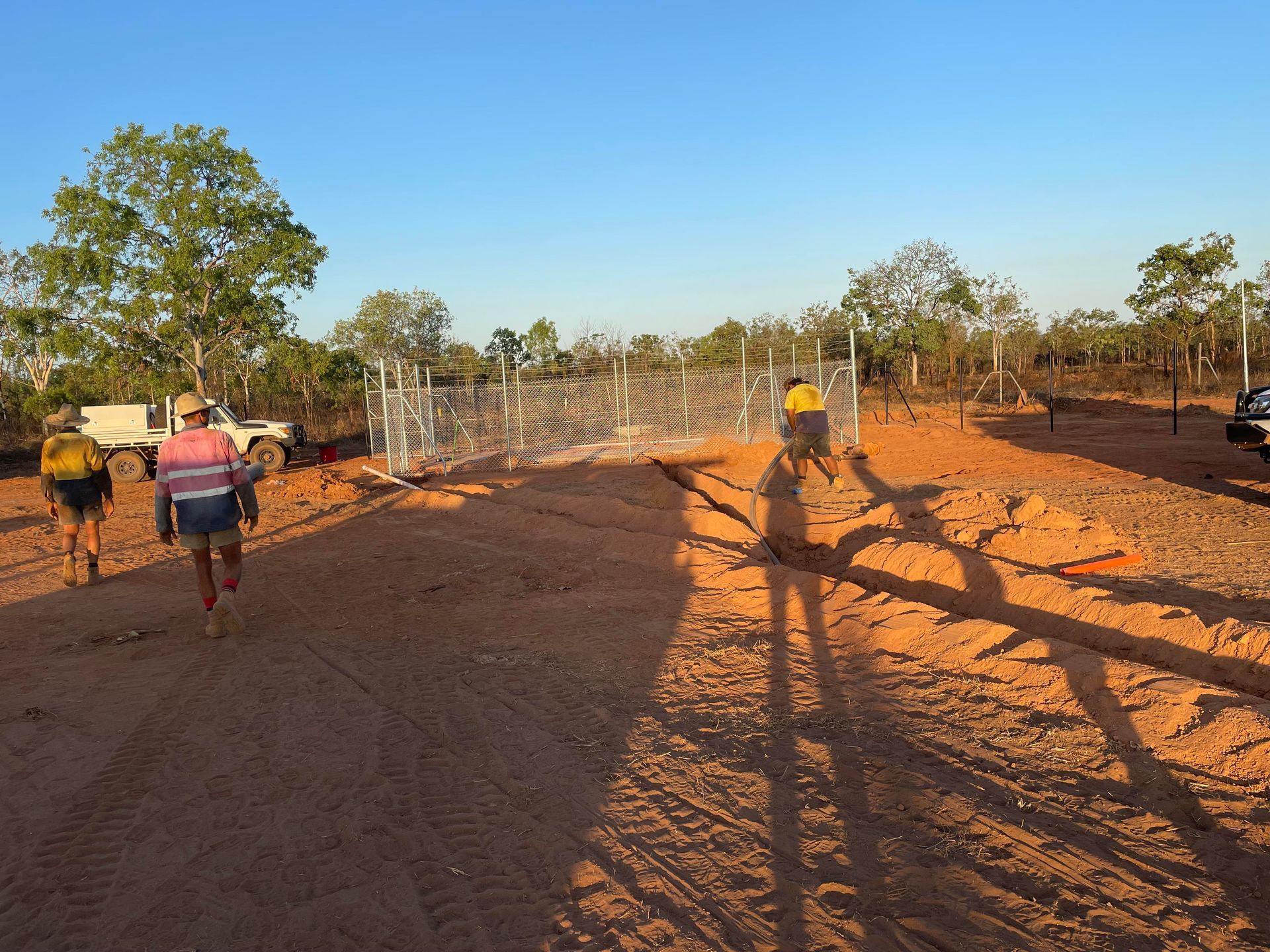 A group of people are walking down a dirt road
