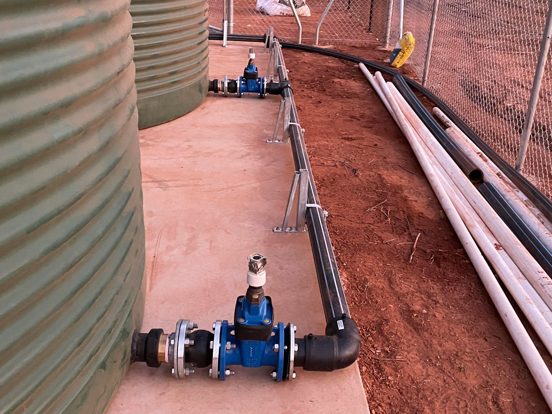 A row of water tanks with pipes attached to them