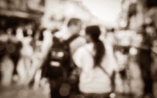 man and woman walk in busy street