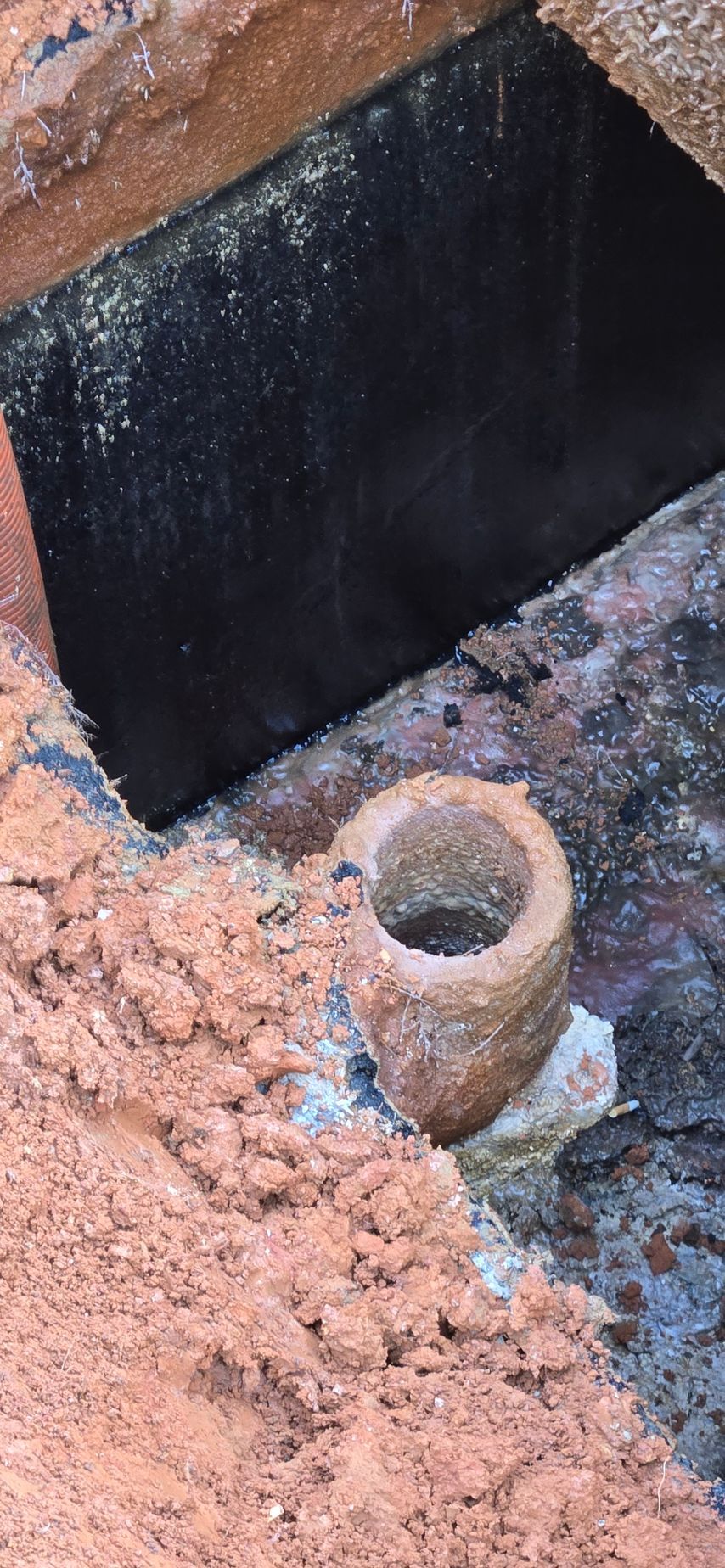 A close-up of a brick structure with a circular opening. 