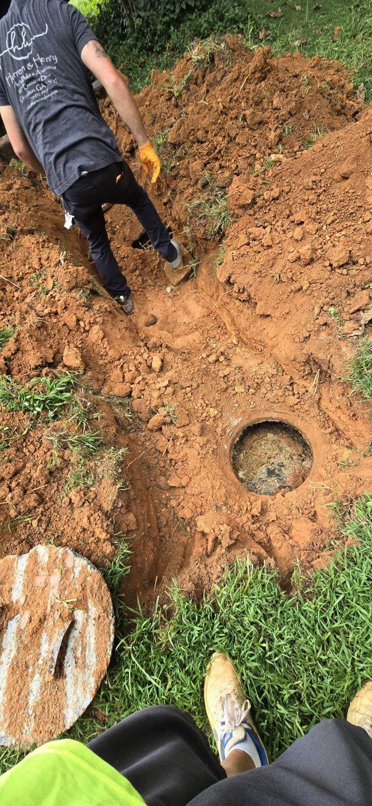 A person digs a trench in the ground.