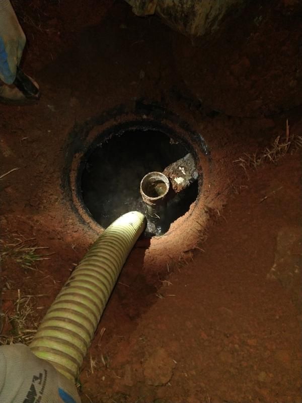 Yellow hose inserted into a round floor drain with a small metal fitting inside.