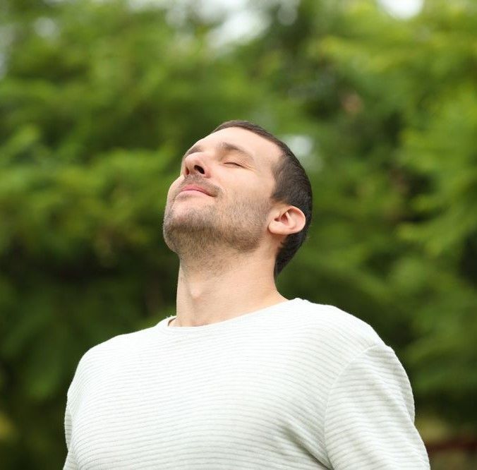 Adult Man Breathing Fresh Air In A Forest — Dieticians, Herbalists & Naturopaths in Kincumber, NSW