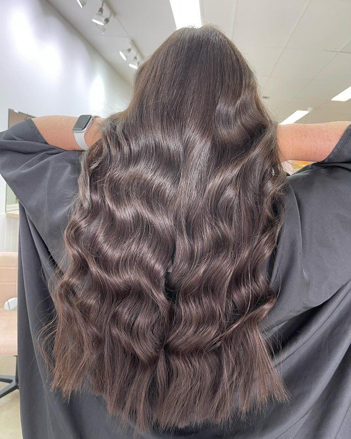 A Woman With Long Brown Hair With Her Hands Behind Her Head — The Hair Boutique Co In Varsity Lakes, QLD