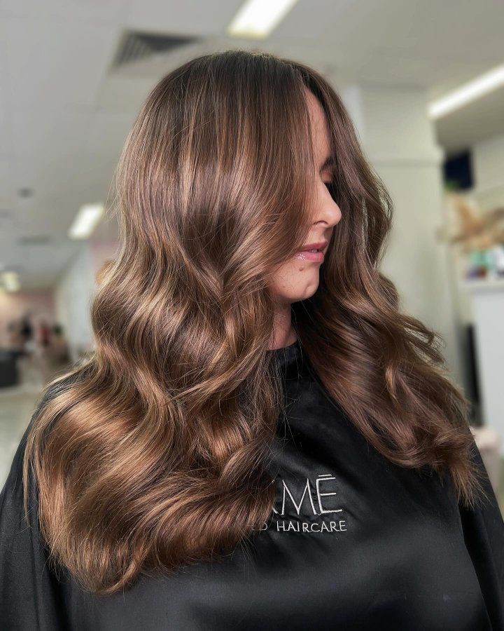 A Woman With Long Brown Hair Is Getting Her Hair Done In A Salon — The Hair Boutique Co In Varsity Lakes, QLD