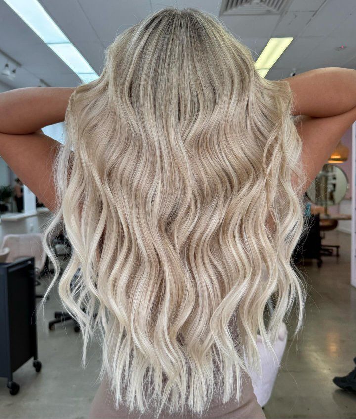 A Woman With Blonde Hair Is Wearing A Salon Cape — The Hair Boutique Co In Varsity Lakes, QLD