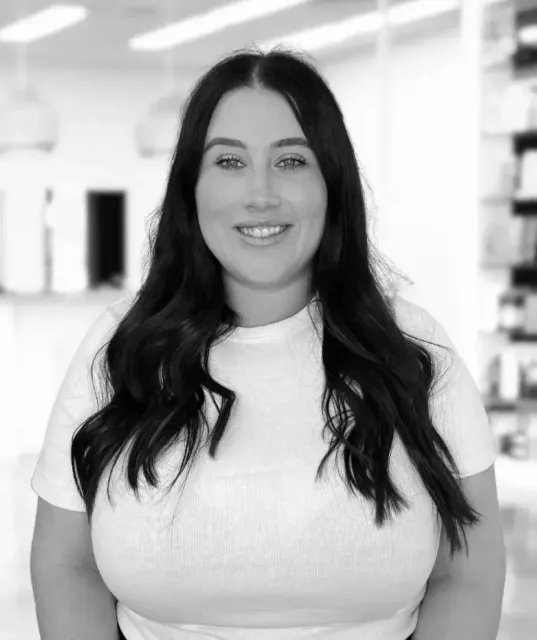 A black and white photo of a woman in a white shirt.