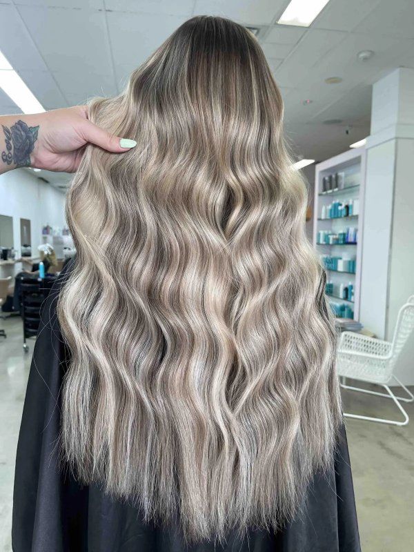 A Woman With Long Blonde Hair Is Getting Her Hair Cut In A Salon — The Hair Boutique Co In Varsity Lakes, QLD
