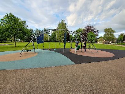 Outdoor playground with climbing structures on colorful safety surfacing in a park