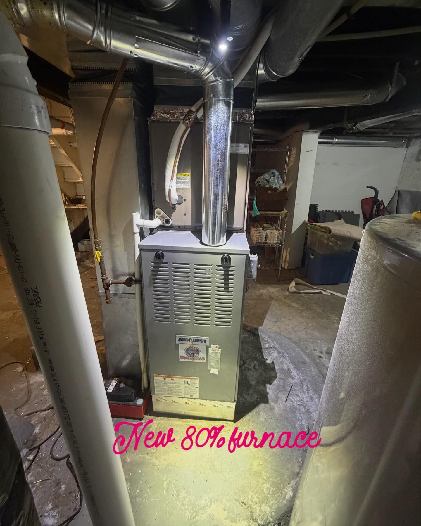 New 80% furnace in a basement. Silver metal appliance with ductwork and PVC pipes.