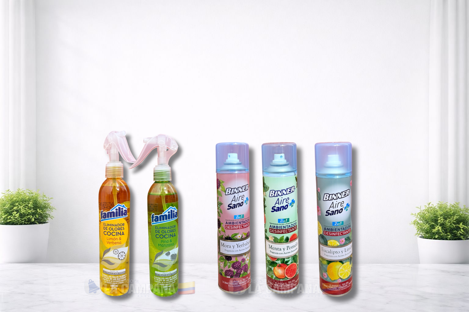 Assorted colorful bottled drinks and soy milk cartons arranged on a white tabletop with small potted plants.