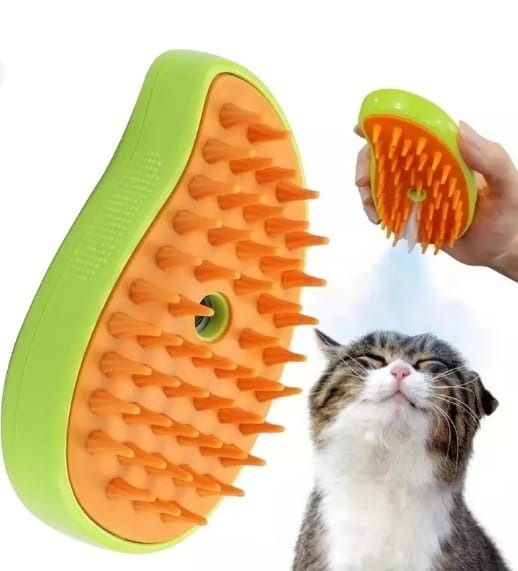 Cepillo de gato verde y naranja rociando agua sobre un gato, que tiene los ojos cerrados.