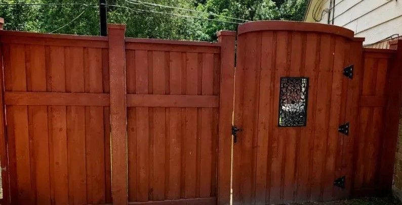 A wooden fence with a gate in the middle of it.