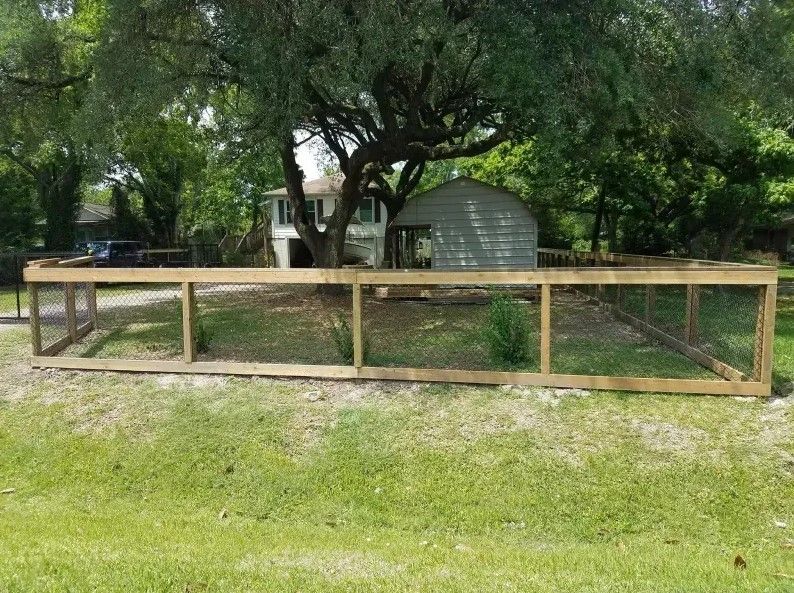 A wooden fence is sitting in the grass in front of a house.