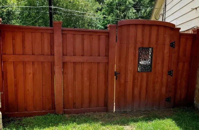 A wooden fence with a gate in the backyard.