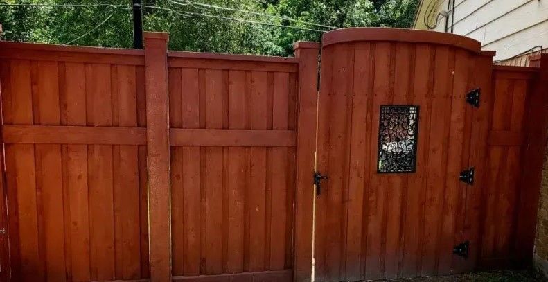 A wooden fence with a gate in the middle of it.