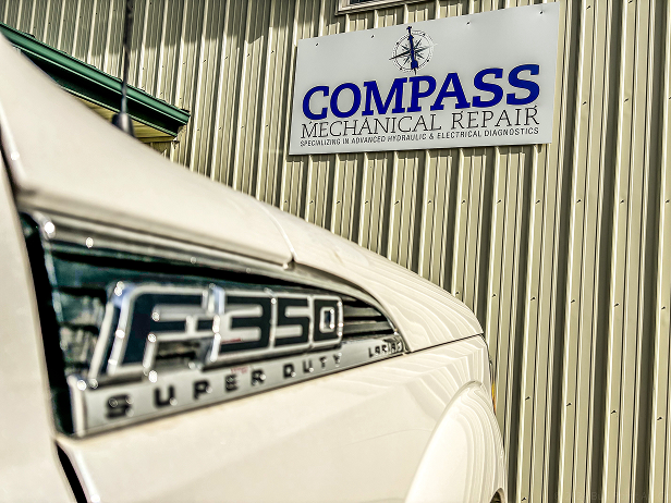 F-350 Super Duty Truck parked in front of our shop with sign | Compass Mechanical Repair