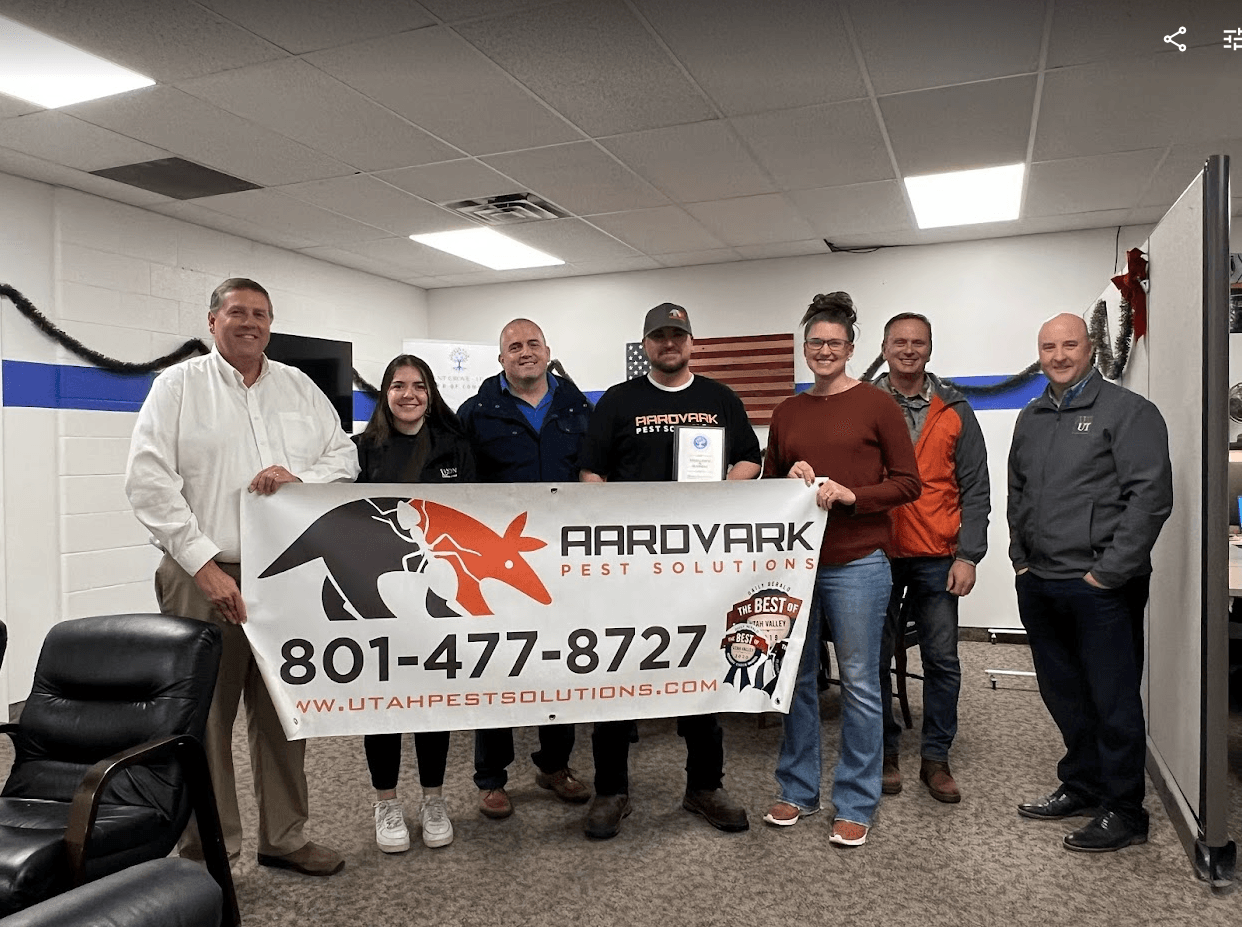 A group of people are standing in a room holding a sign.