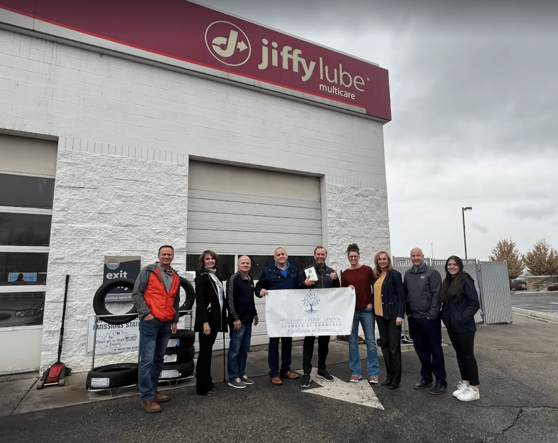 A group of people are standing in front of a jiffy lube store.