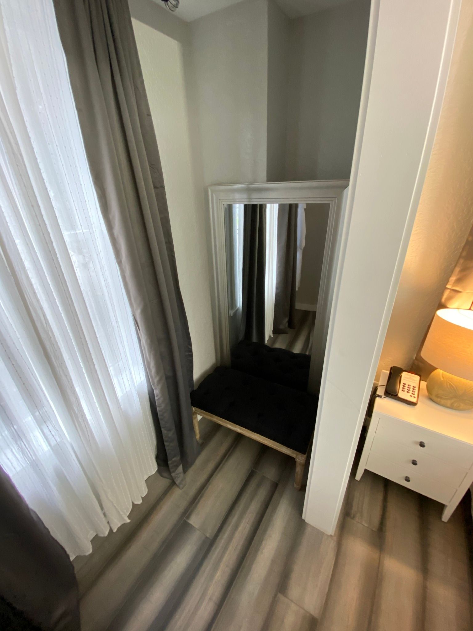 A dressing room with a large mirror and a bench.