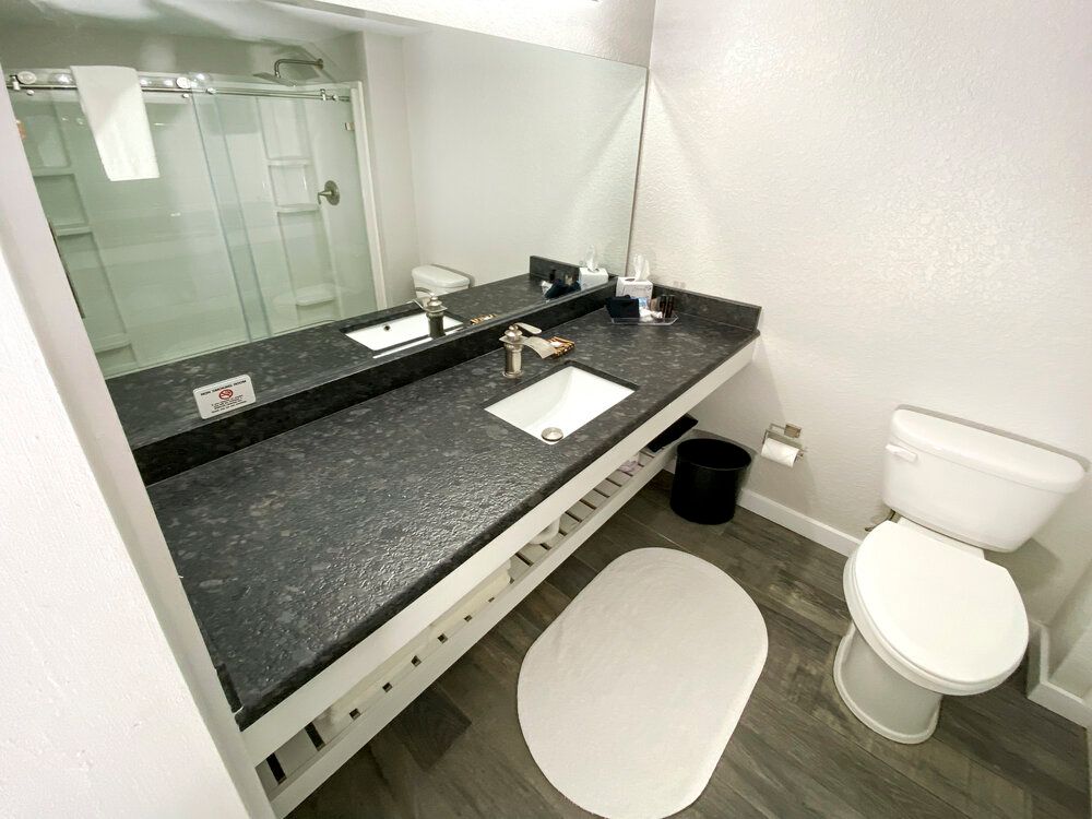 A bathroom with a toilet , sink and mirror