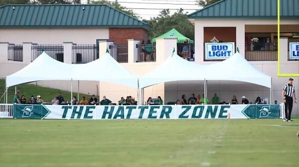 A football field with a large stadium in the background
