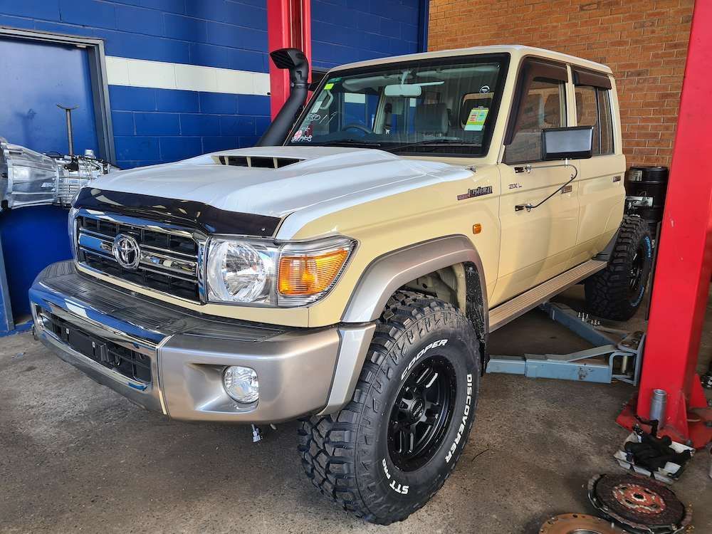 Beige and White Toyota Land Cruiser on a Lift in a Mechanic — Greens Diesel Tune in Camden, NSW