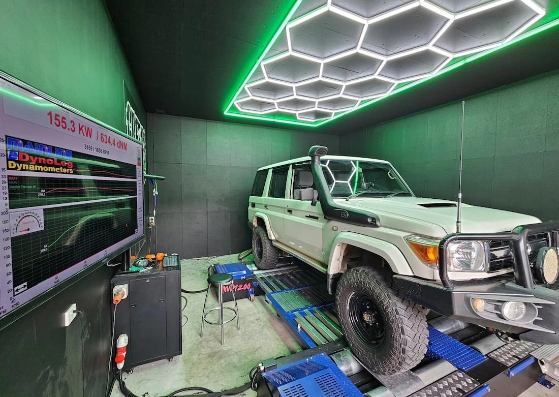 White Suv on a Dynamometer in a Green-lit Room — Greens Diesel Tune in Camden, NSW