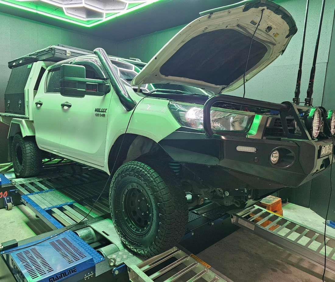 White Off-road Truck With Hood Open on a Dyno Machine in a Garage — Greens Diesel Tune in Smeaton Grange, NSW