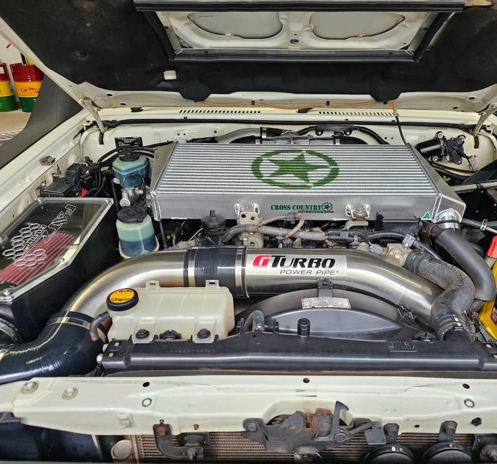 Engine Bay of a White Vehicle, Featuring a Large Intercooler — Greens Diesel Tune in Smeaton Grange, NSW
