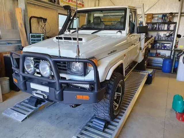 White Toyota Land Cruiser Pickup Truck on Ramps Inside a Garage
— Greens Diesel Tune in Camden, NSW