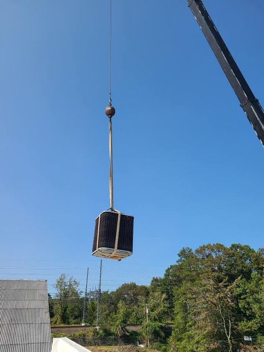 A crane is lifting a large box in the air