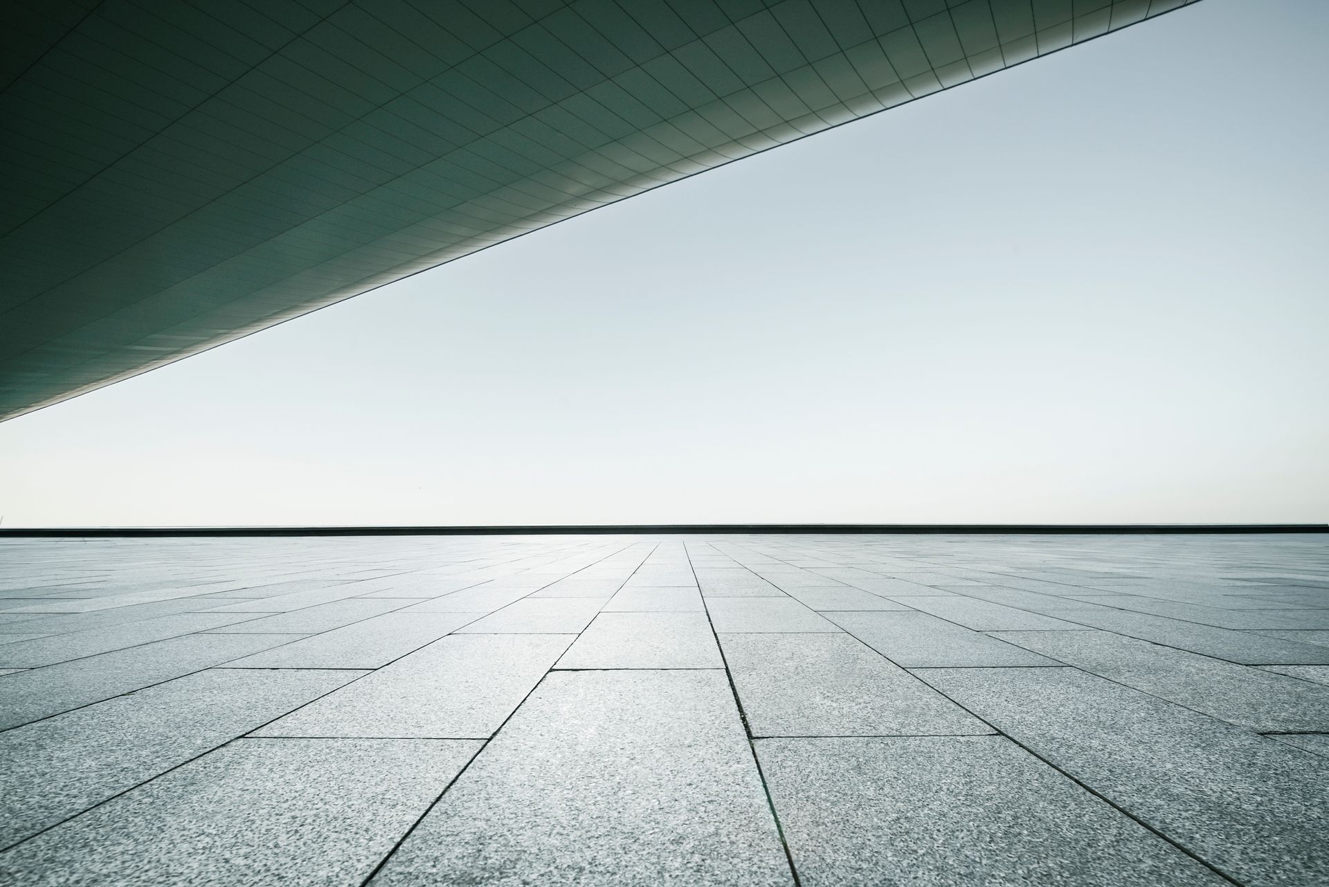 An Empty Concrete Floor with A Building in The Background - Mingo, IA - Karns Concrete LLC