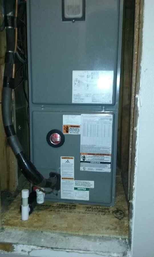 A furnace is sitting in a room next to a door.