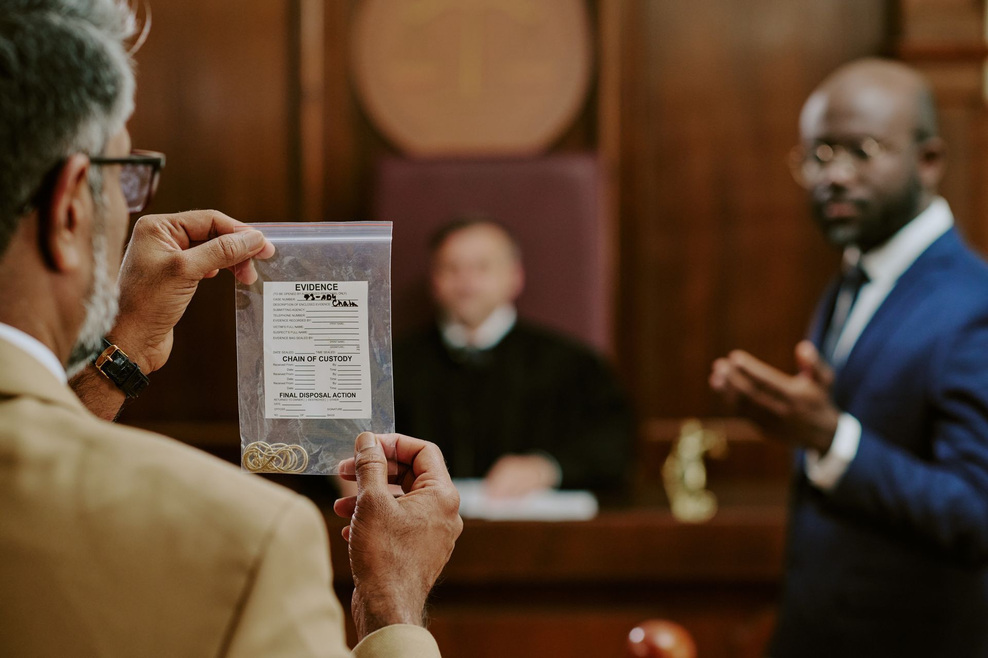 An attorney holds up an evidence bag during courtroom proceedings with a judge An attorney holds up an evidence bag during courtroom proceedings with a judge