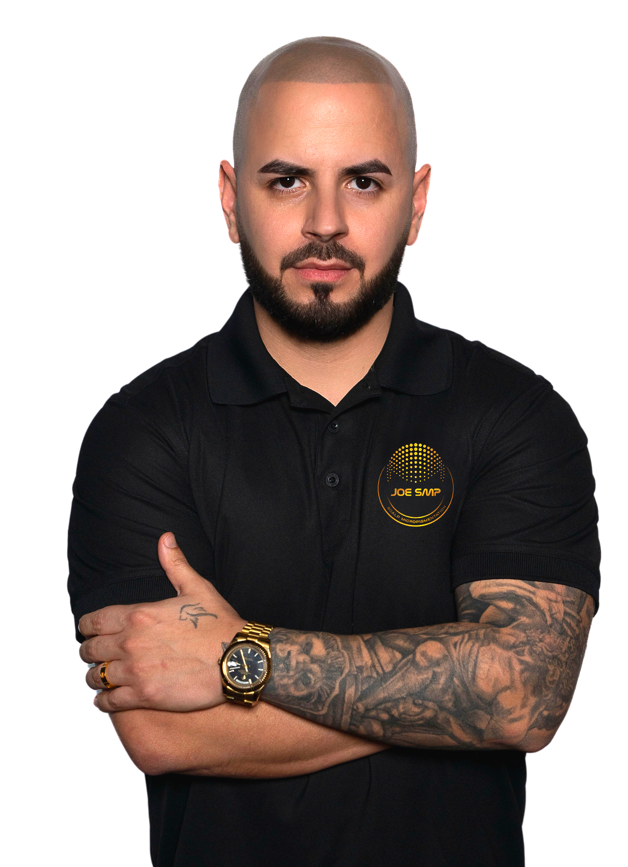 Man with shaved head and beard in a black polo shirt, arms crossed, tattoos visible.