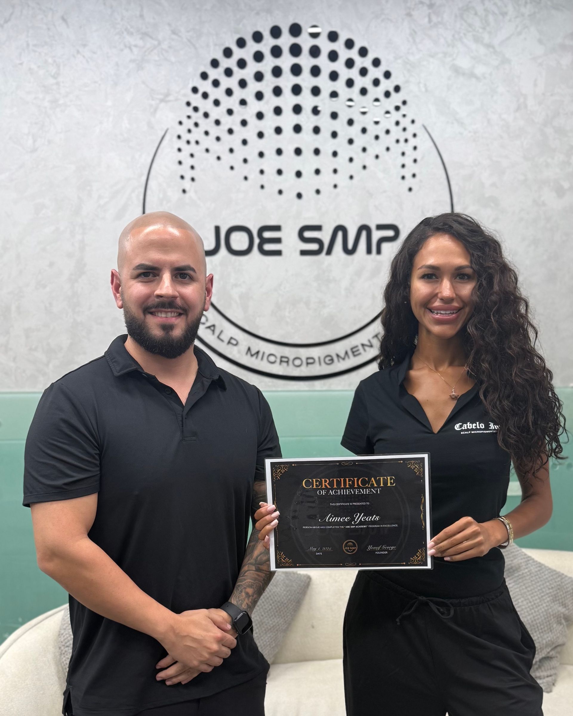 Man and woman holding a certificate in front of a