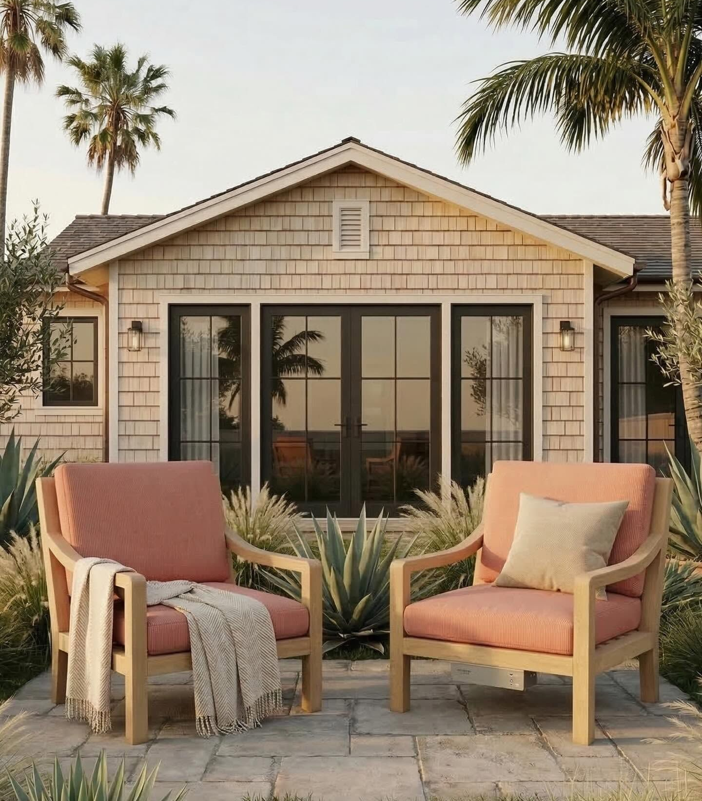 Two outdoor chairs in front of a shingled house