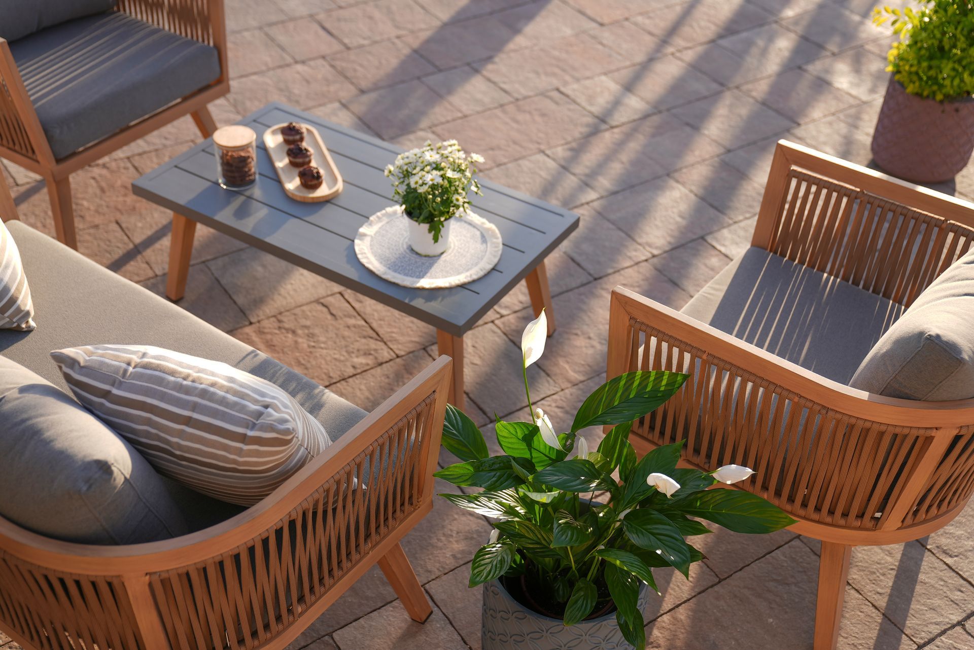 View of wood sofa and table made of metal and wood on a patio outdoors.