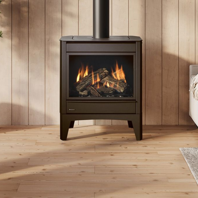 Modern white fireplace with black chimney in a minimalist white room, next to a built-in bookshelf.