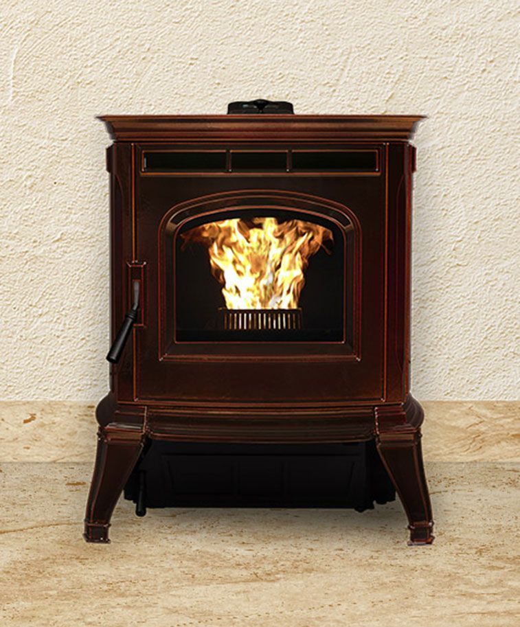 A dark brown pellet stove with a fire burning inside, set against a light tan wall.