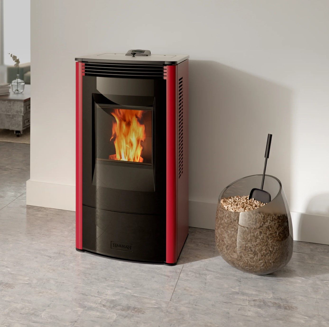 A red pellet stove with a glass door and a fire burning inside, next to a glass container of wood pellets.